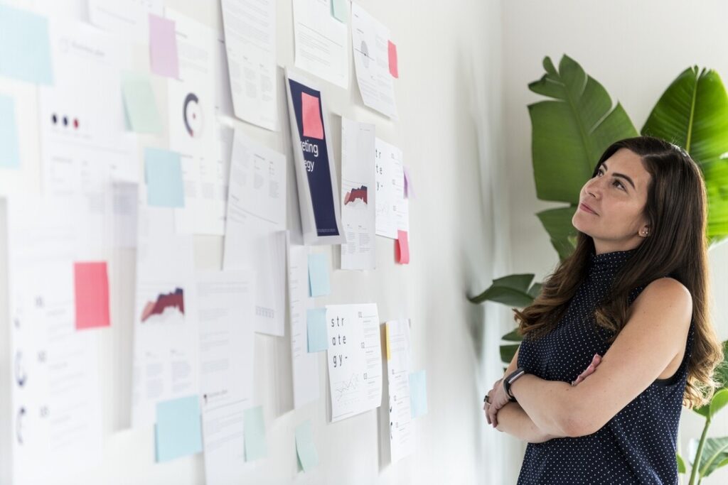 woman stands in front of her demand generation marketing idea board
